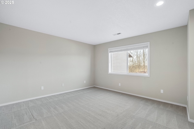 spare room featuring light carpet