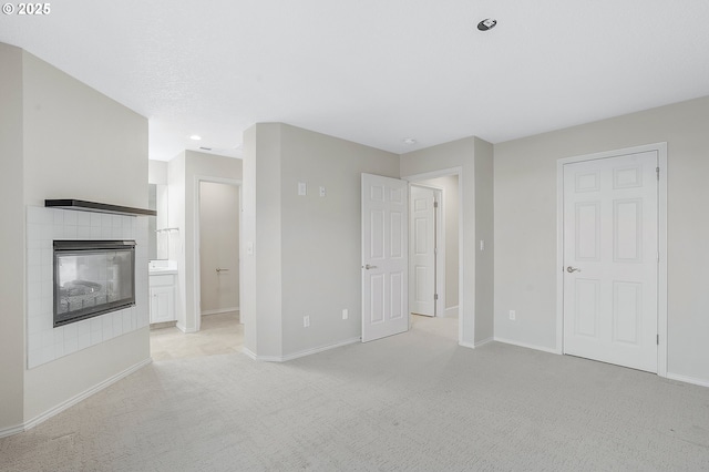 unfurnished living room featuring a fireplace and light colored carpet