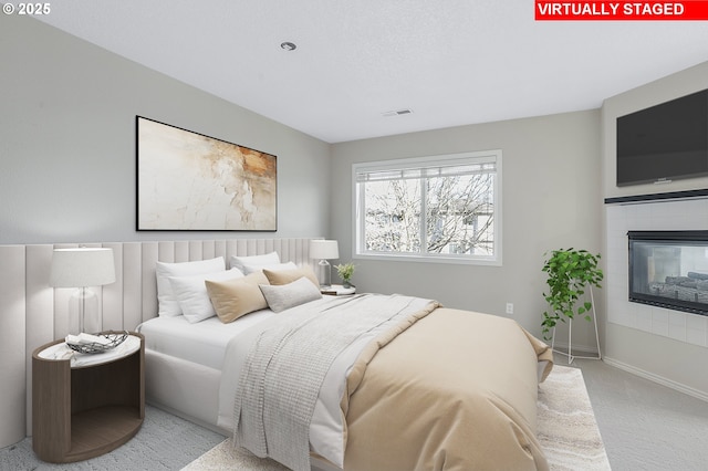 bedroom with a tile fireplace