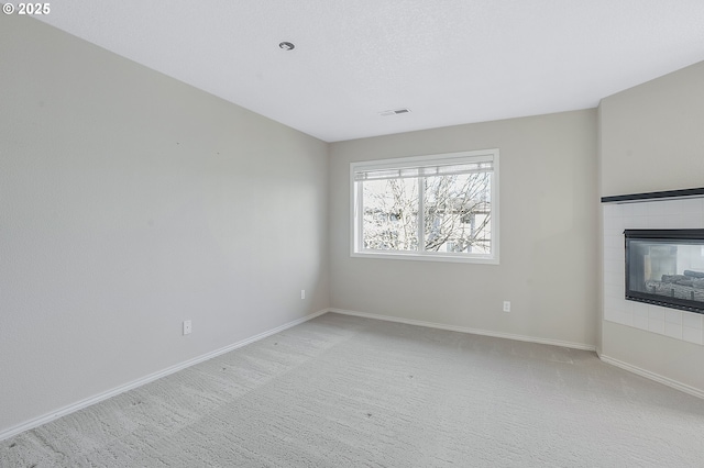 interior space featuring a fireplace, light carpet, and a textured ceiling