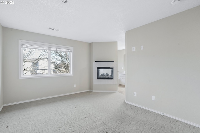 unfurnished living room with light carpet and a textured ceiling