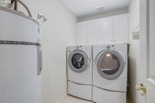 clothes washing area featuring cabinets and separate washer and dryer