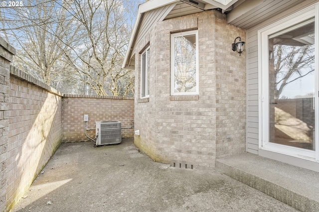 view of side of property featuring central AC unit and a patio