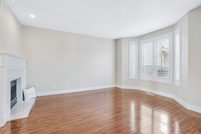 unfurnished living room featuring a textured ceiling and light wood-type flooring