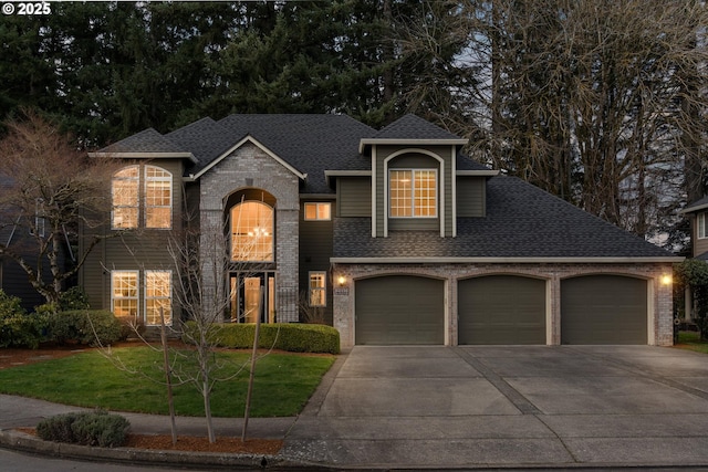 traditional-style house with roof with shingles, concrete driveway, a front yard, a garage, and brick siding