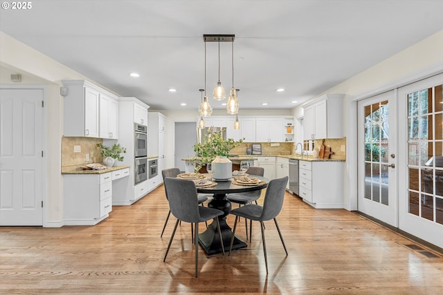 dining room with recessed lighting, french doors, visible vents, and light wood finished floors