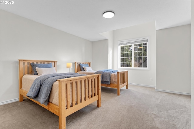 bedroom with light colored carpet and baseboards