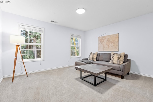 carpeted living room featuring a healthy amount of sunlight, visible vents, and baseboards