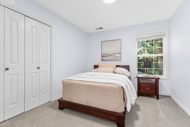 carpeted bedroom featuring baseboards, visible vents, and a closet