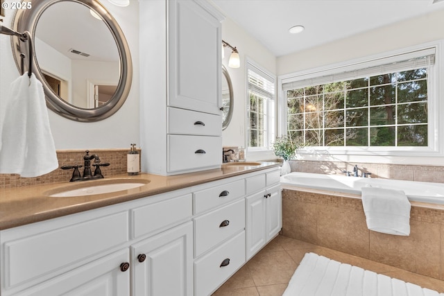 bathroom featuring a sink, visible vents, a garden tub, and tile patterned flooring