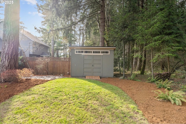 view of yard with a storage unit, an outdoor structure, and fence