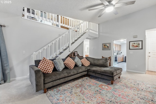 14938 SW 109th Ave, Portland, OR 97224 - living room featuring ceiling fan, stairway, light colored carpet, a textured ceiling, and baseboards