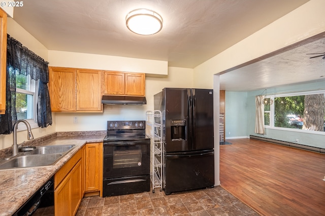 3198 Pheasant Blvd, Springfield, OR 97477 - kitchen with black appliances, under cabinet range hood, baseboard heating, and brown cabinetry
