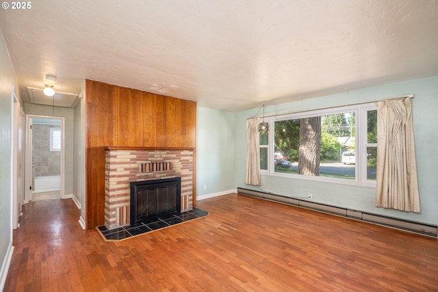 3198 Pheasant Blvd, Springfield, OR 97477 - unfurnished living room with a baseboard heating unit, attic access, wood finished floors, and a tile fireplace
