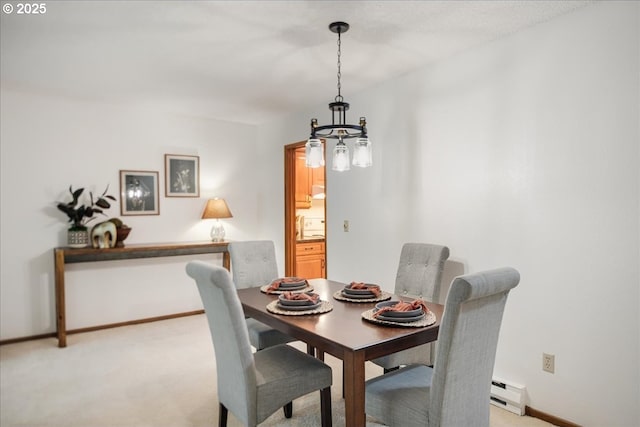 dining room featuring a baseboard radiator, light colored carpet, baseboards, and a chandelier