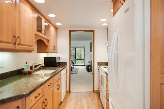 kitchen featuring glass insert cabinets, light brown cabinetry, recessed lighting, white appliances, and a sink