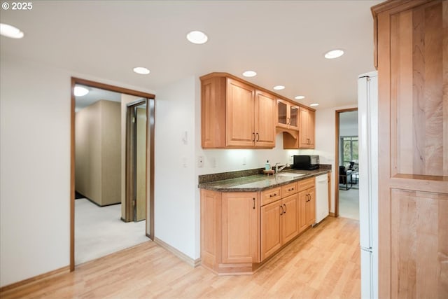 kitchen featuring light wood-style flooring, recessed lighting, white dishwasher, and a sink
