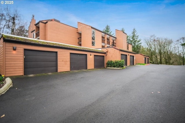 exterior space with community garages and a chimney