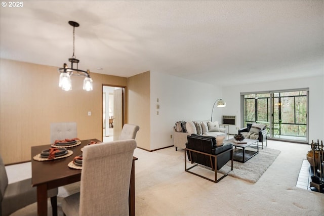 dining room featuring baseboards, light colored carpet, and a chandelier