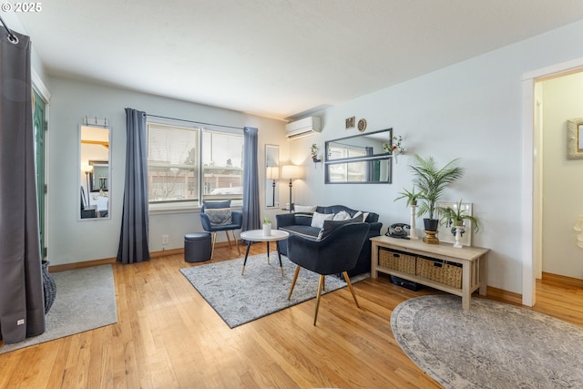 living area featuring baseboards, wood finished floors, and a wall mounted AC