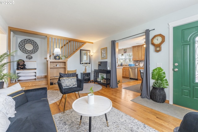 living area featuring light wood-style flooring and stairs