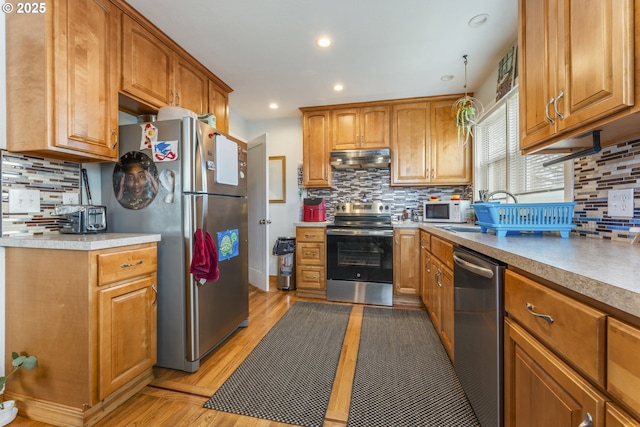 kitchen with under cabinet range hood, tasteful backsplash, and appliances with stainless steel finishes