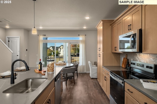 kitchen with pendant lighting, sink, appliances with stainless steel finishes, dark hardwood / wood-style floors, and decorative backsplash