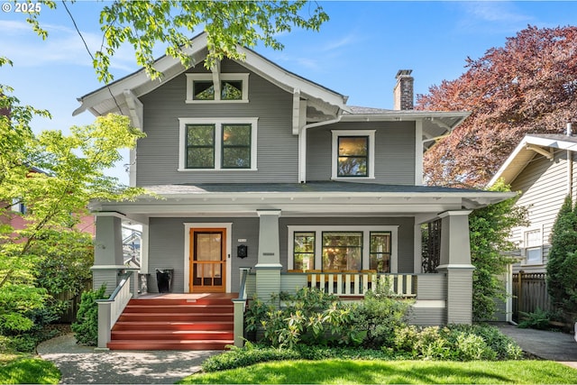 view of front of home featuring covered porch and a chimney