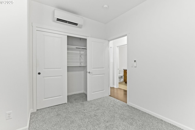 3963 N Montana Ave Unit 1, Portland, OR 97227 - unfurnished bedroom featuring an AC wall unit, baseboards, carpet flooring, and a closet