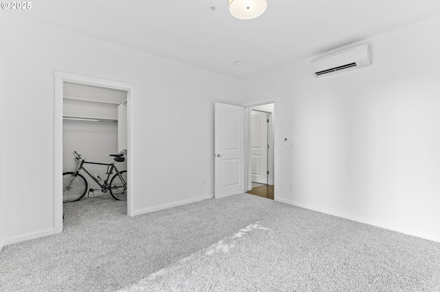3963 N Montana Ave Unit 1, Portland, OR 97227 - unfurnished bedroom featuring an AC wall unit, carpet, a walk in closet, and baseboards