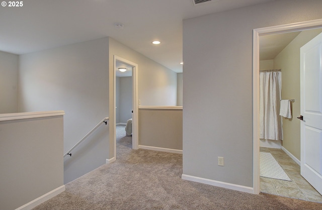 hall featuring light colored carpet