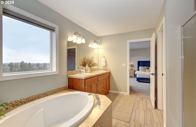 bathroom featuring vanity and tiled bath