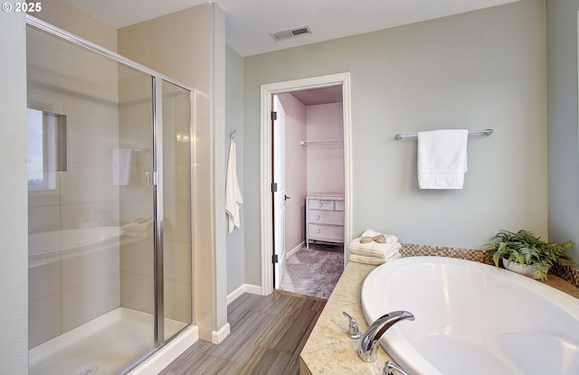 bathroom with hardwood / wood-style flooring and separate shower and tub