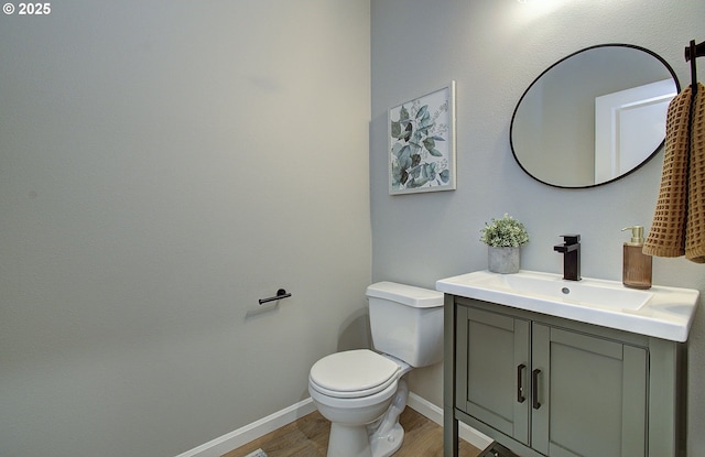 bathroom with vanity, wood-type flooring, and toilet