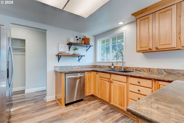 kitchen featuring appliances with stainless steel finishes, sink, light brown cabinets, and light hardwood / wood-style floors