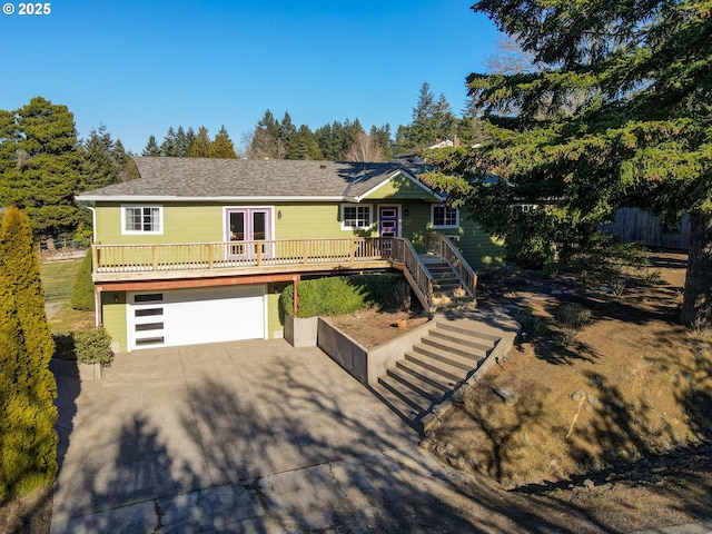 view of front of property featuring french doors, a garage, and a wooden deck