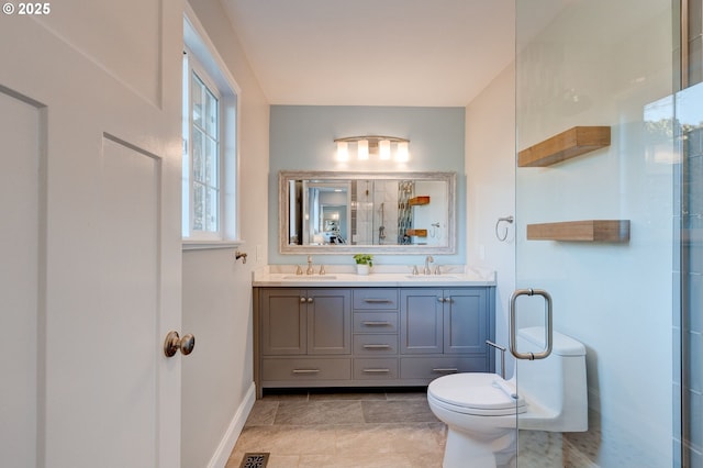 bathroom featuring vanity, toilet, and a shower with door