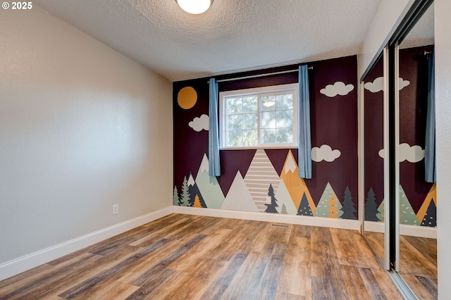 spare room with wood-type flooring and a textured ceiling