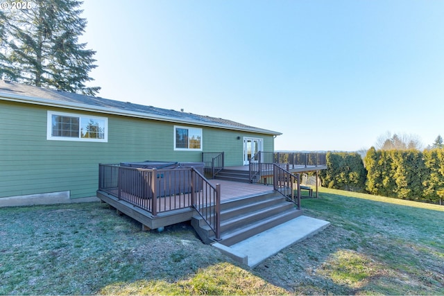 rear view of property with a wooden deck and a lawn