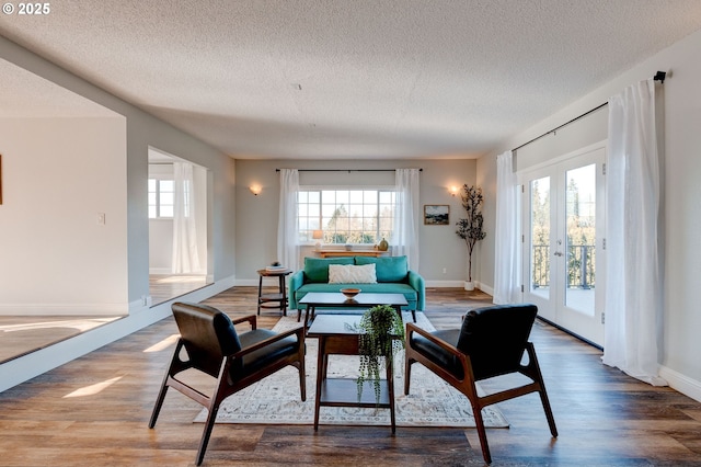 living area featuring hardwood / wood-style flooring, french doors, and a textured ceiling