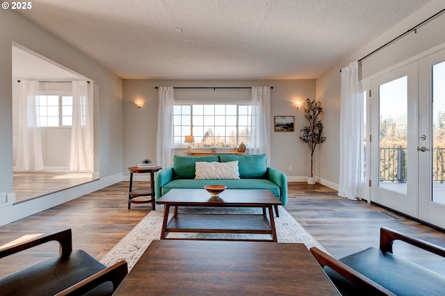 living room featuring hardwood / wood-style floors, french doors, and a textured ceiling