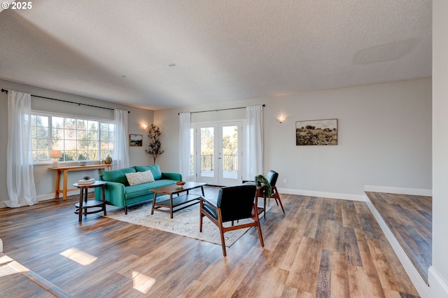 living room featuring hardwood / wood-style flooring, a textured ceiling, and french doors