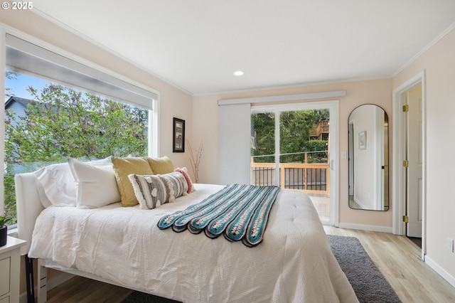 bedroom featuring multiple windows, wood finished floors, access to outside, and crown molding