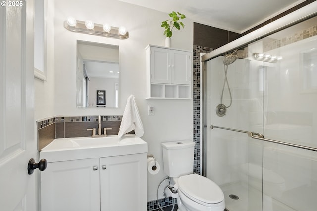 bathroom with vanity, a shower stall, and toilet
