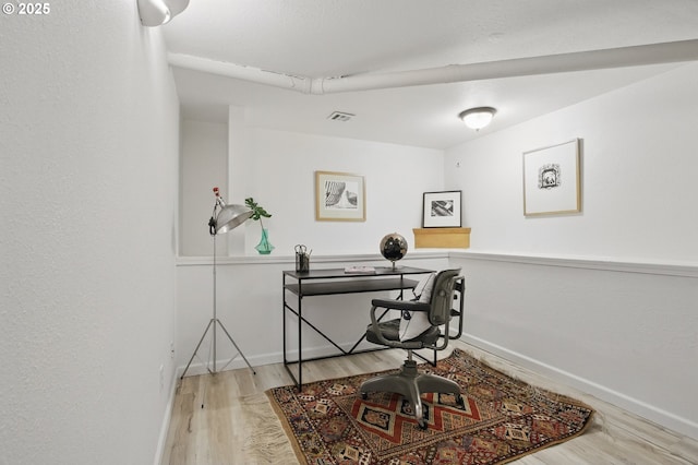 office with baseboards, wood finished floors, and visible vents