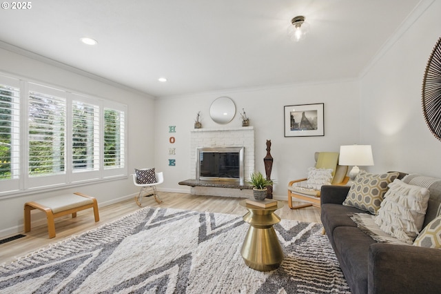 living room featuring baseboards, recessed lighting, a brick fireplace, wood finished floors, and ornamental molding