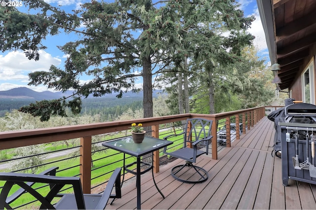 wooden deck featuring a mountain view and area for grilling