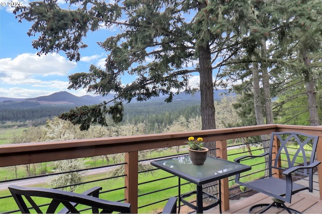 wooden terrace featuring a mountain view and a forest view