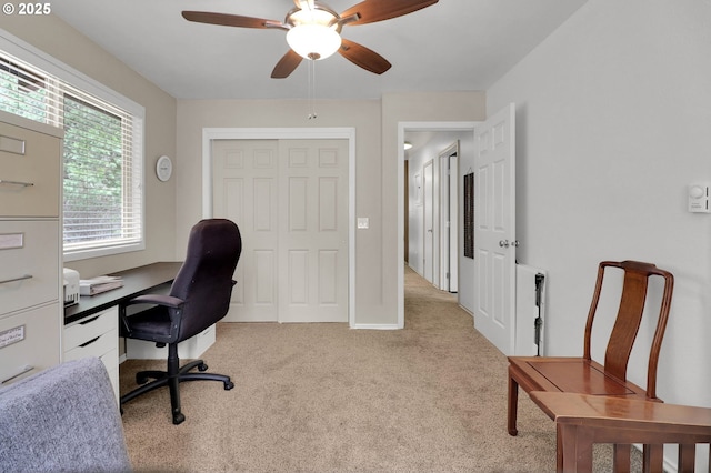 home office featuring light carpet and a ceiling fan