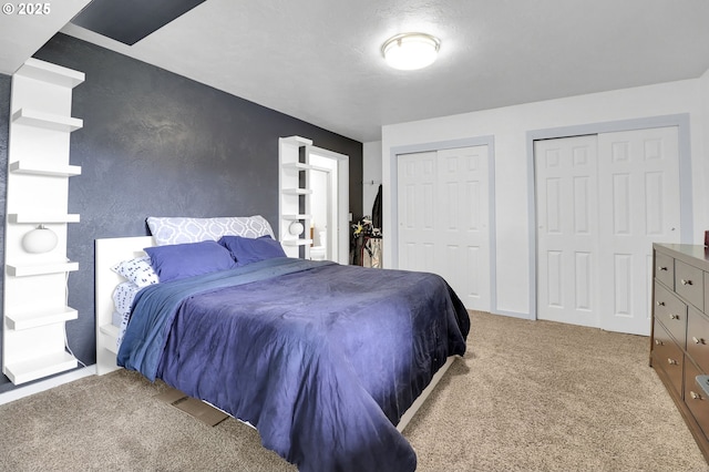 carpeted bedroom with two closets